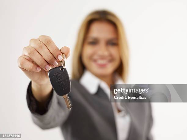 elegant woman holding a car key with her right hand - car keys hand stockfoto's en -beelden