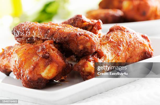 a white plate of spicy chicken wings - chicken wings plate stock pictures, royalty-free photos & images