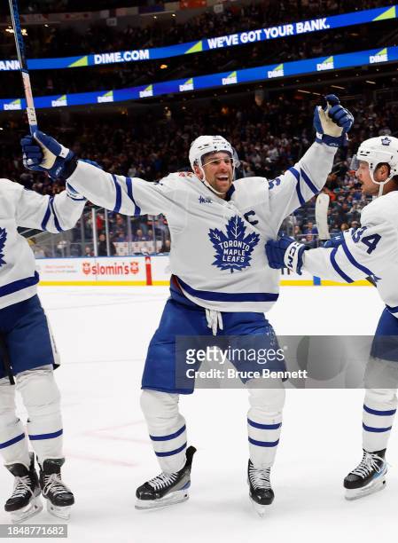 John Tavares of the Toronto Maple Leafs celebrates his assist and 1000th NHL point against the New York Islanders during the third period at UBS...