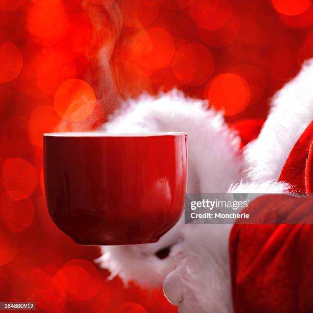 santa hält eine tasse heißes getränk - kaffeepause stock-fotos und bilder