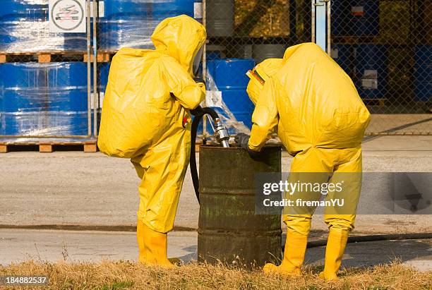 people in yellow suits collecting hazardous material - biochemical weapon stock pictures, royalty-free photos & images