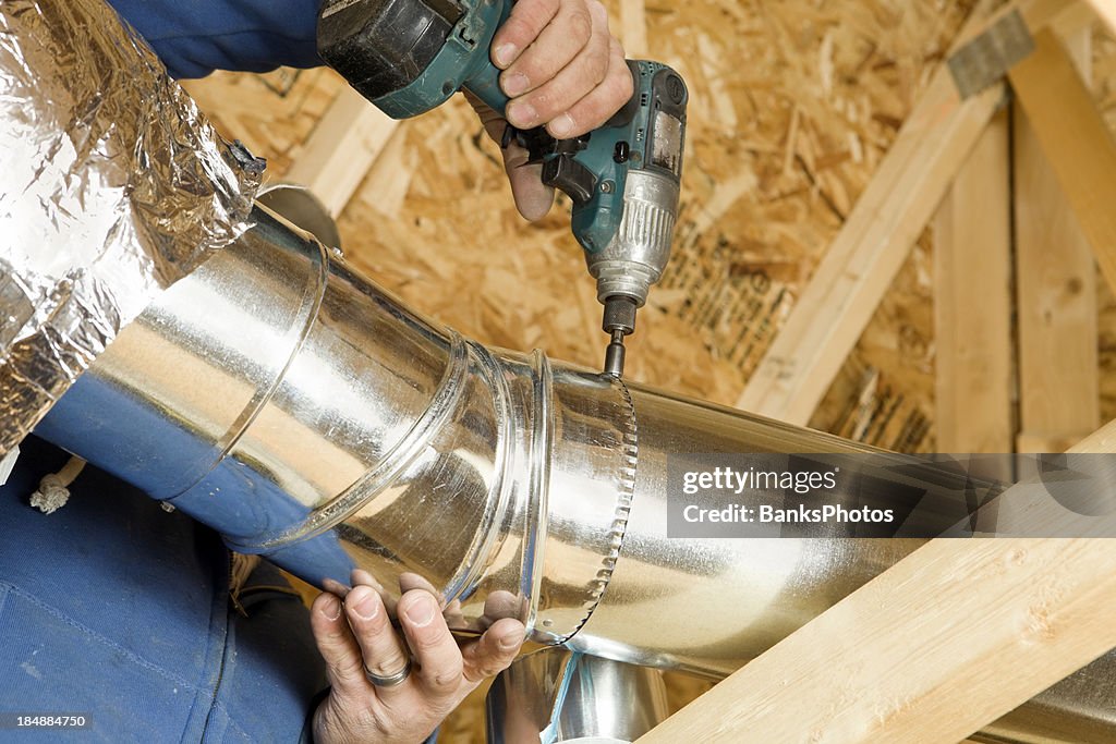 Worker Installing an Attic Vent Duct