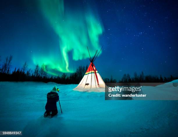aurora above lit teepee in canada - yellowknife canada stock pictures, royalty-free photos & images