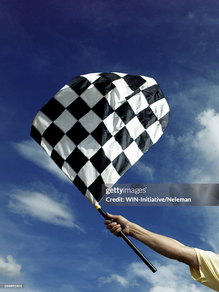 Hand holding a checkered flag