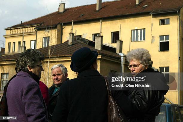 People stand near a building March 14, 2003 in the Serbian capitol of Belgrade. The building is suspected of being the location where two sniper...