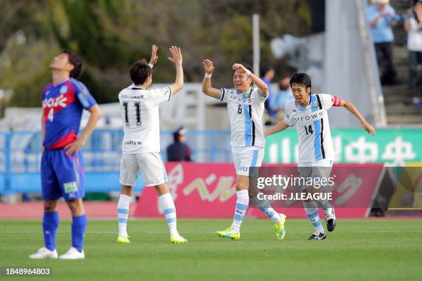 Yusuke Tasaka of Kawasaki Frontale celebrates with teammates Yu Kobayashi and Kengo Nakamura after scoring the team's fourth goal during the J.League...