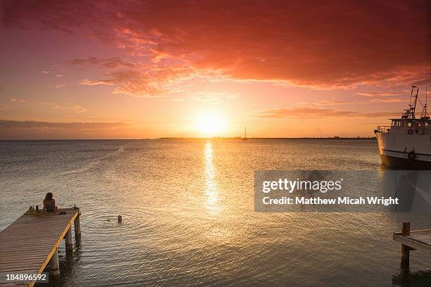 women watching sunset - utila honduras stock pictures, royalty-free photos & images