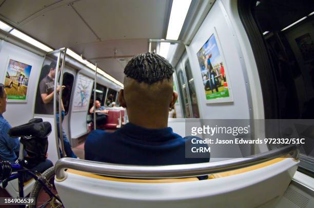Passengers ride a train through a darkened subway tunnel. Washington Metropolitan Area Transit Authority, Washington, District of Columbia, United...
