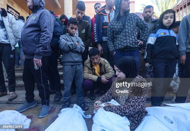 Graphic content / A woman mourns over the body of a boy killed in Israeli bombardment on Khan Yunis in the southern Gaza Strip, are laid out for...