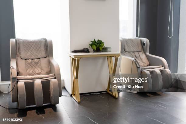 two automatic massage chairs in the lounge - massagestuhl stock-fotos und bilder