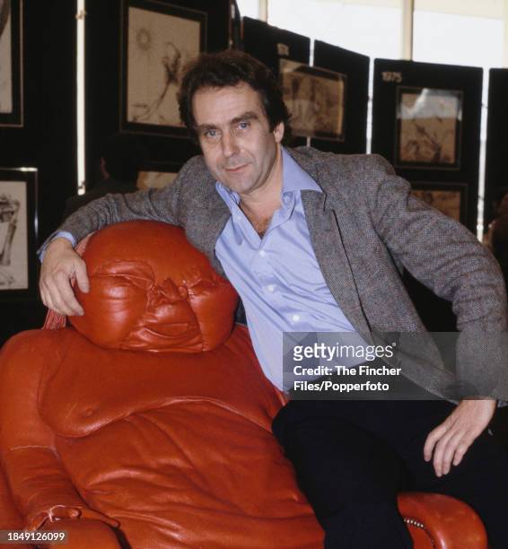 British artist Gerald Scarfe sitting on his "Chairman Mao" creation, at an exhibition in London, England in March 1983.