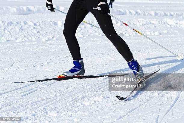 shot of legs in black attire cross country skiing - biathlon ski stock pictures, royalty-free photos & images