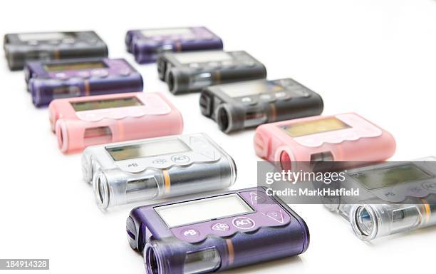 lineup of multiple colored insulin pumps - insulin pump stock pictures, royalty-free photos & images