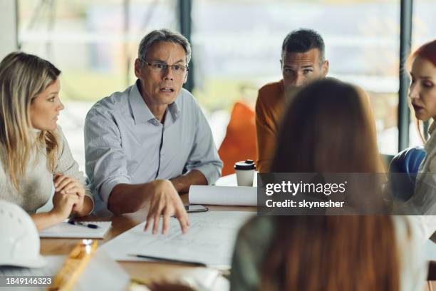 displeased architect talking to his colleagues on a meeting in the office. - in the dog house stock pictures, royalty-free photos & images