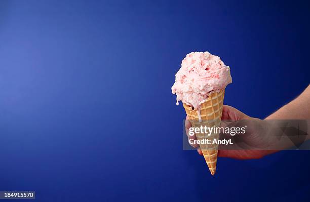 strawberry ice cream cone on blue with space for copy - aardbeienijs stockfoto's en -beelden