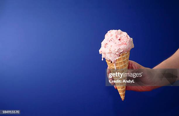 strawberry ice cream cone on blue with space for copy - strawberry ice cream stock pictures, royalty-free photos & images