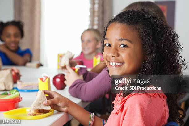 little girl having lunch in school classroom - juice box stock pictures, royalty-free photos & images