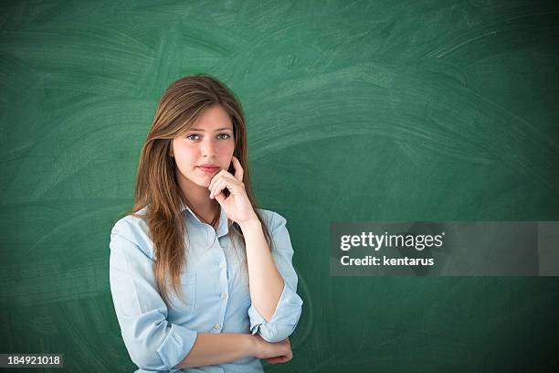 woman with thinking expression in front of green board - kentarus stock pictures, royalty-free photos & images