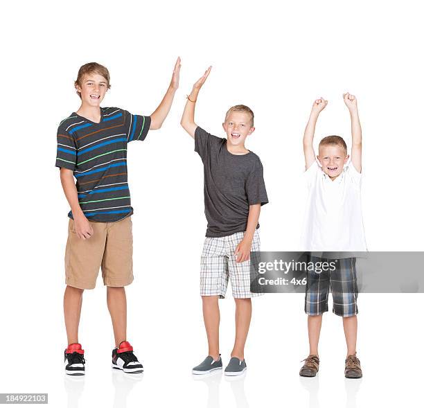 portrait of three boys cheering - teen boy shorts stock pictures, royalty-free photos & images