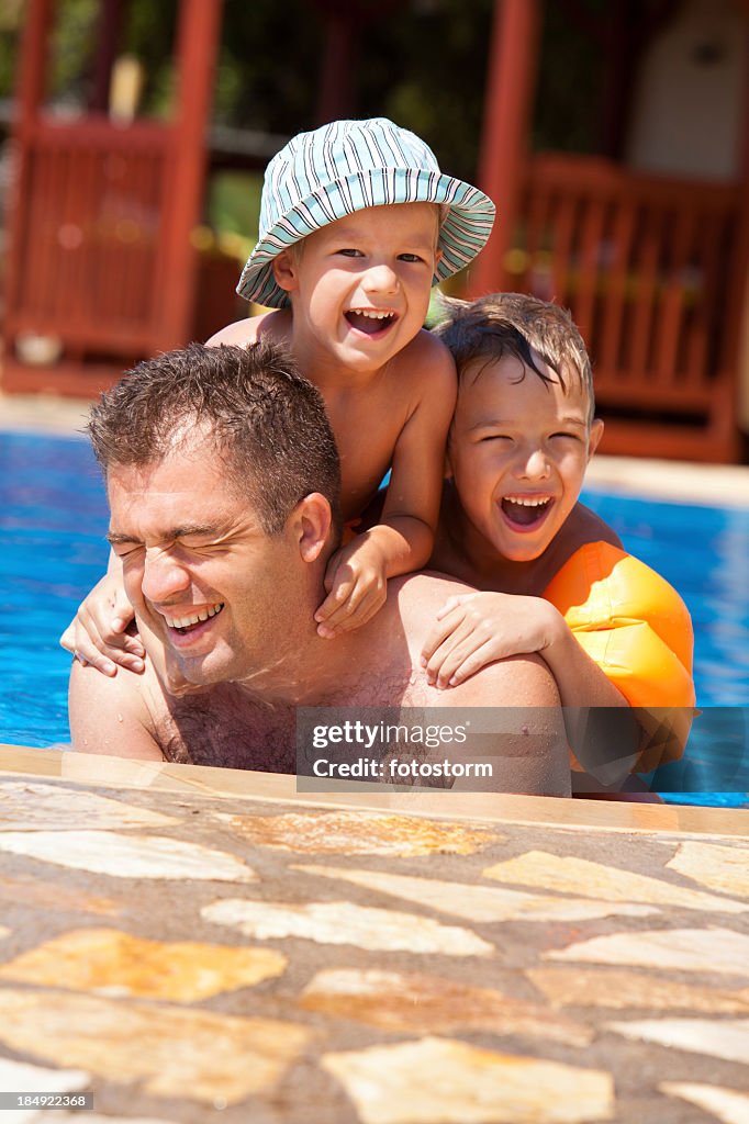 Father and children enjoying in the swimming pool