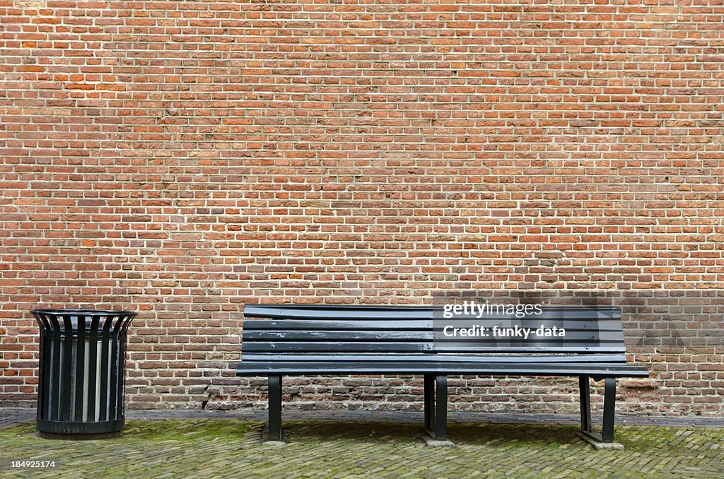 Empty bench and garbage bin