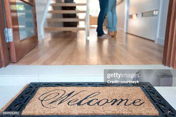 glückliches junges paar ihren neuen haus stehen im - welcome mat stock-fotos und bilder