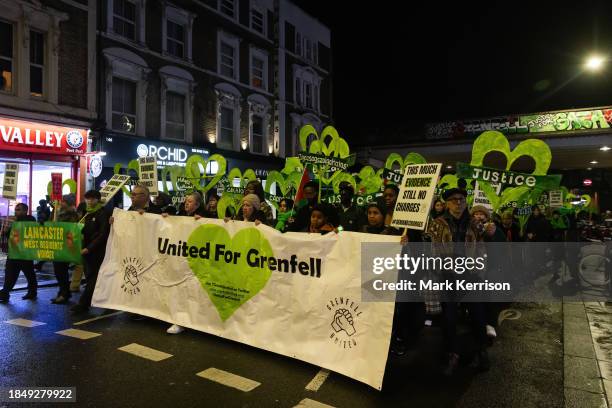 Members of the Grenfell community and supporters pause beneath the Westway during the Grenfell Silent Walk around West Kensington on 14th December...