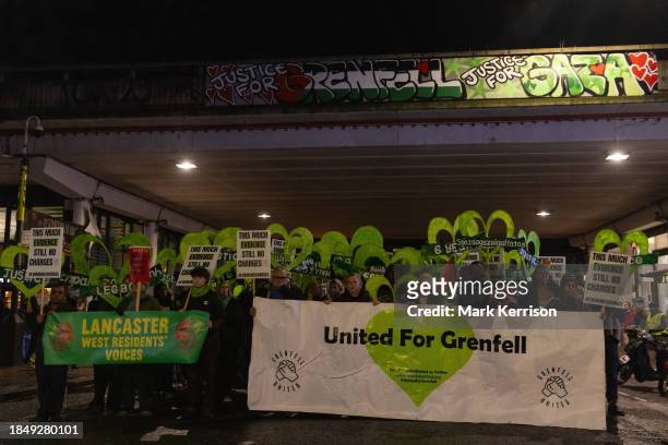 Members of the Grenfell community and supporters pause beneath the Westway during the Grenfell Silent Walk around West Kensington on 14th December...