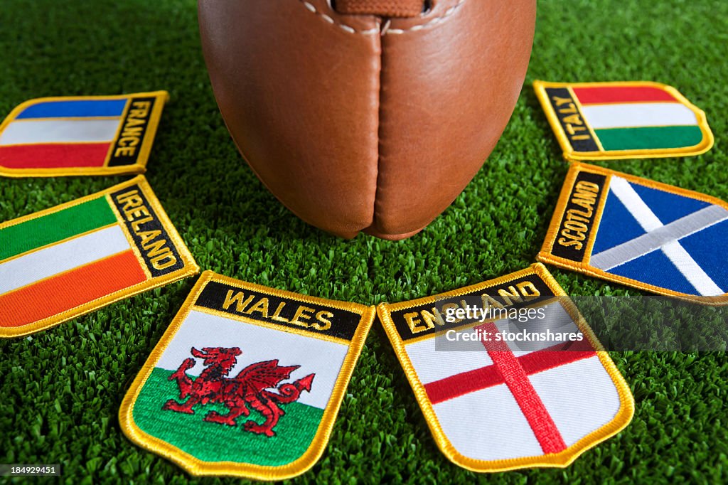 Six different nation's badges for rugby around a rugby ball