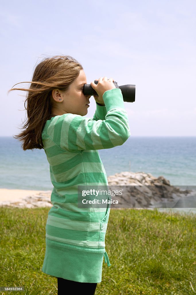 Ragazza guardando attraverso un binocolo.