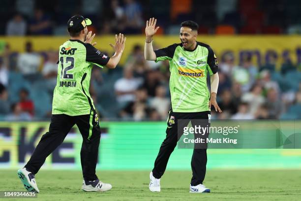 Tanveer Sangha of the Thunder celebrates with team mates after taking the wicket of Matt Renshaw of the Heat during the BBL match between Sydney...