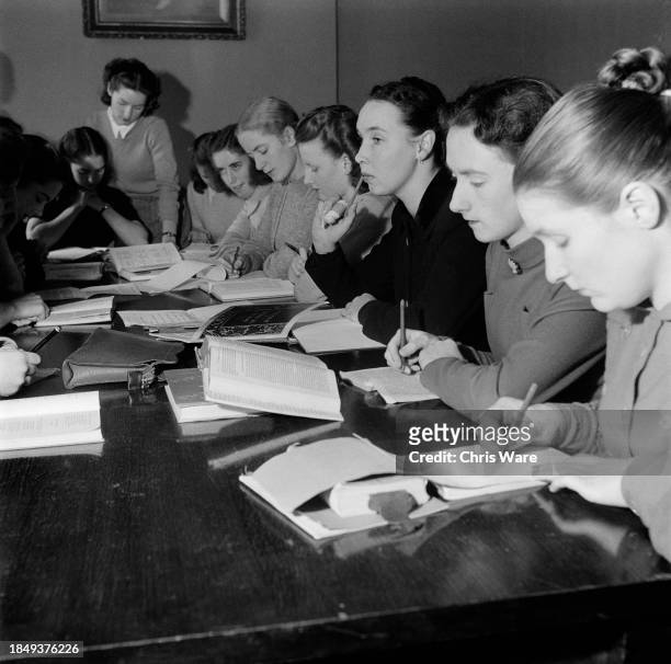 Students enrolled on the Royal Academy of Dance's Teachers' Training Course pictured during an English lesson, London, December 1948. The women study...
