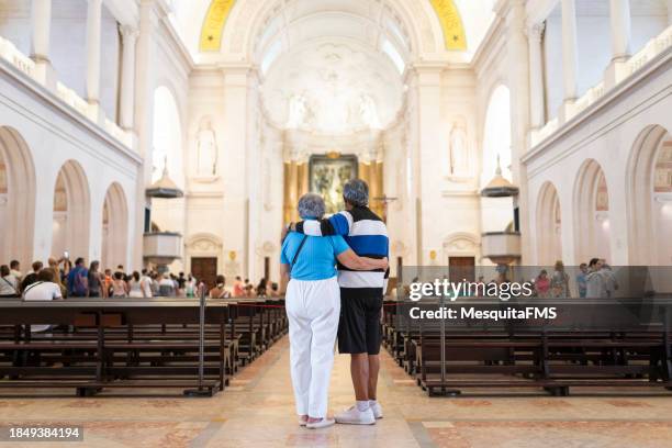 ältere menschen beten im heiligtum von fátima - worshipper stock-fotos und bilder