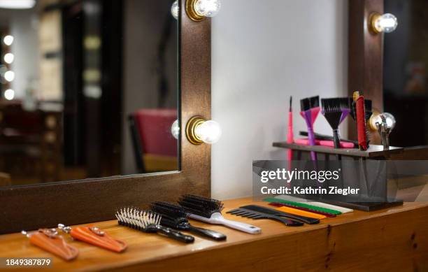 haircutting tools and brushes on dressing table - salão-de-cabeleireiro imagens e fotografias de stock