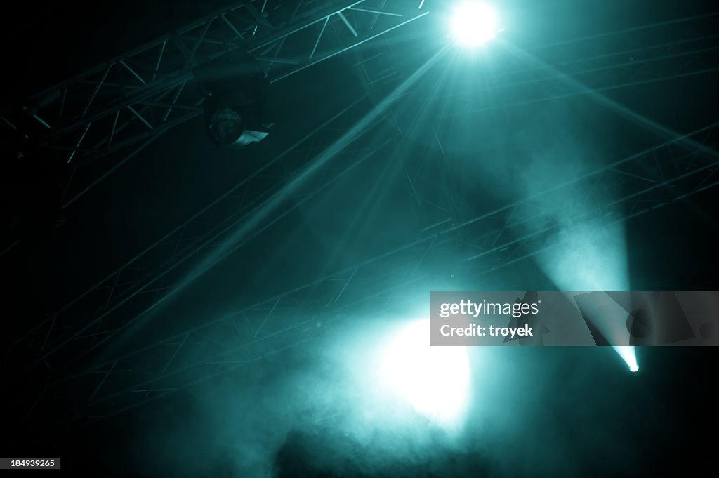 A view of foggy stage lights emerging from the dark