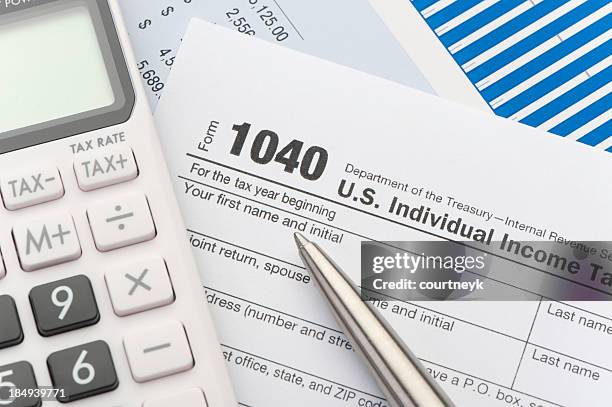 close up of a tax return form - calculator tax forms stockfoto's en -beelden