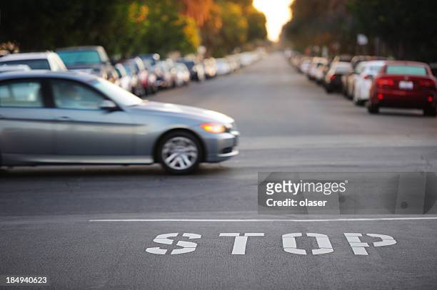 road junction, stop word, motion blurred car - stop enkel woord stockfoto's en -beelden