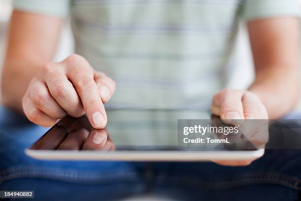 manos sosteniendo tablet pc - un solo hombre fotografías e imágenes de stock