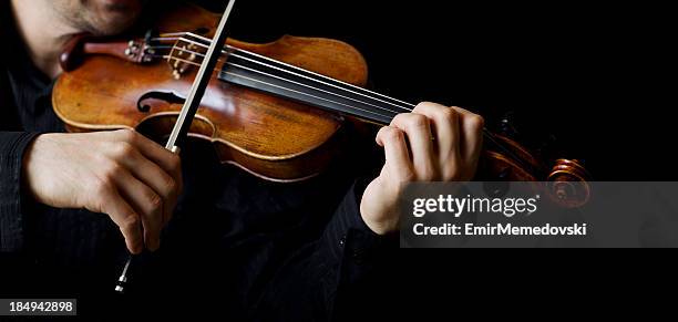 a person playing the violin showing hands holding the bow - violin bridge stock pictures, royalty-free photos & images