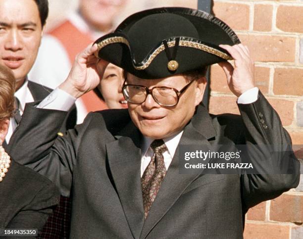 Chinese President Jiang Zemin tries on a traditional 18th century hat in front of the Governor's Palace in Old Colonial Williamsbug, Virginia 28...