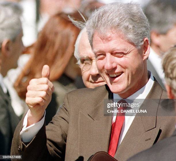 President Bill Clinton flashes thumbs-up to the press 17 October at his arrival in Bariloche, southern Argentina. Clinton is expected to spend the...