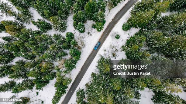 drone/aerial view of a campervan on a mountain pass road in the french alps on a snowy winters day - justin van groen stock pictures, royalty-free photos & images