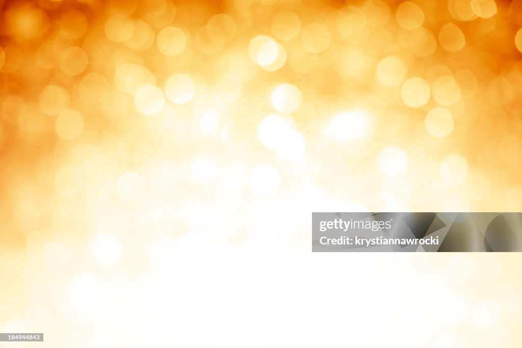 Blurred gold sparkles background with darker top corners