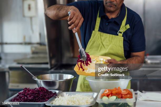 adicionando a salada - pinça utensílio de servir - fotografias e filmes do acervo