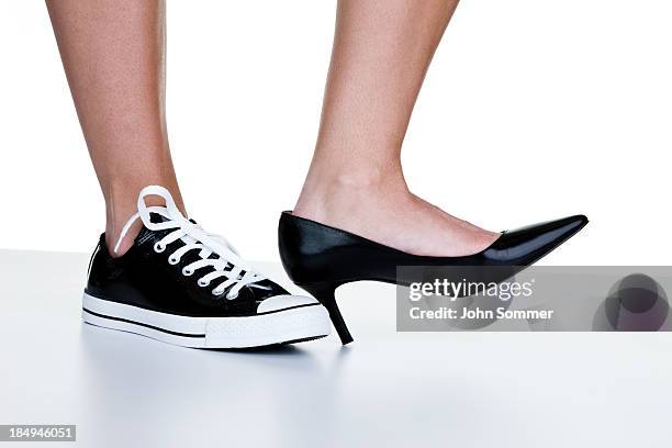 female wearing a dress shoe and sneaker - formal footwear stock pictures, royalty-free photos & images