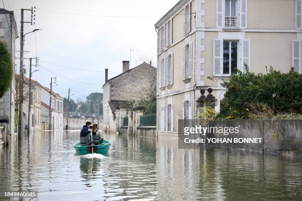 Two person are seen on a bark on a flooded street of Gond-Pontouvre near Angouleme, central France, on 15 December 2023, following the flood of the...