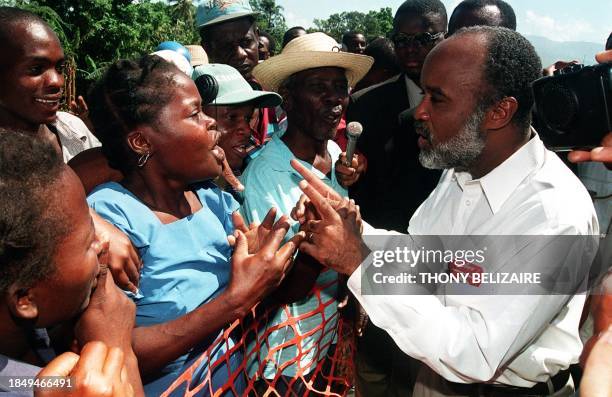 Haitian President Rene Preval talks with local residents of Bon Repos, a neighborhood of the Haitian capital 27 May prior to the inauguration...