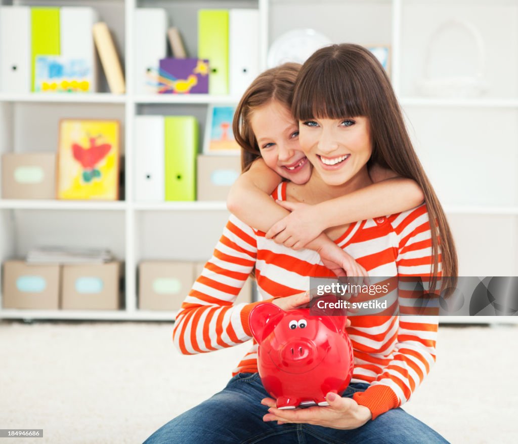 Mother and daughter with piggy bank.