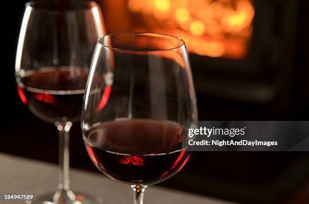 red wine by the fire - red wine glass stock pictures, royalty-free photos & images