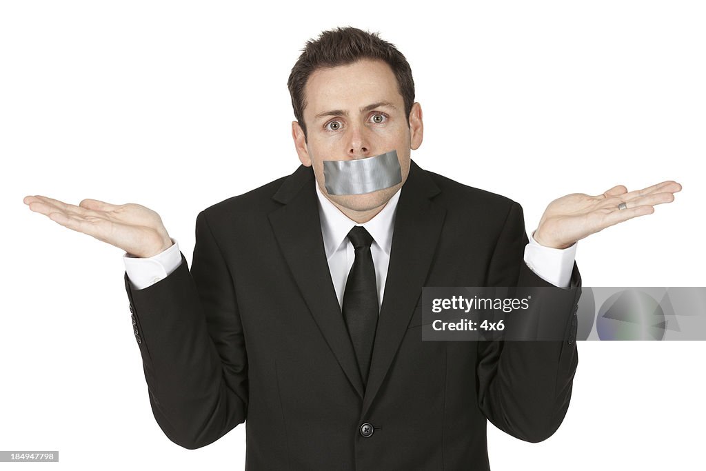 Businessman with sticky tape on his mouth